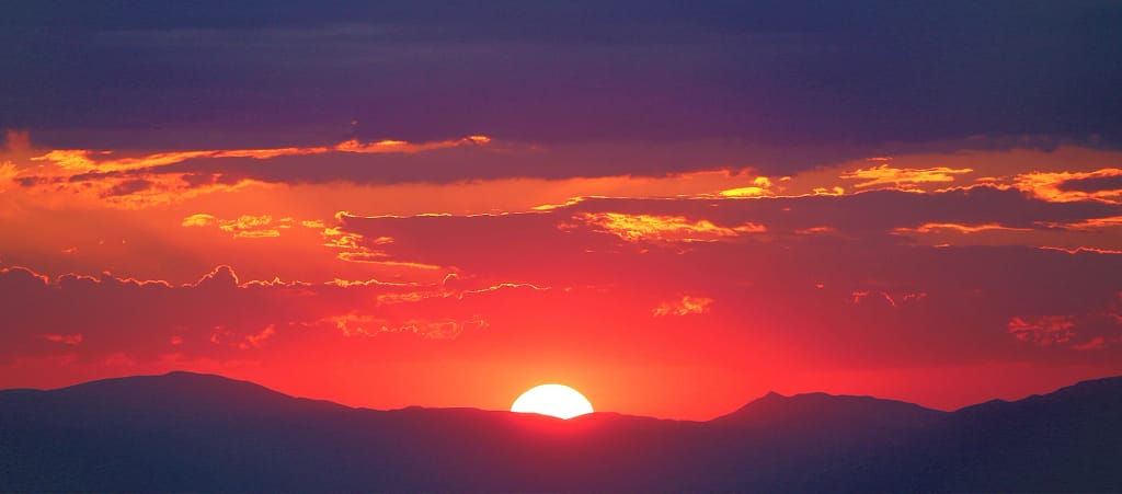 Imagen del alba con sol ardiente y paisaje bucólico para la entrada, Factores de riesgo la piel en verano.