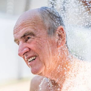 Imagen de apoyo con persona mayor lavandose el cabello con PROPHARM CHAMPU