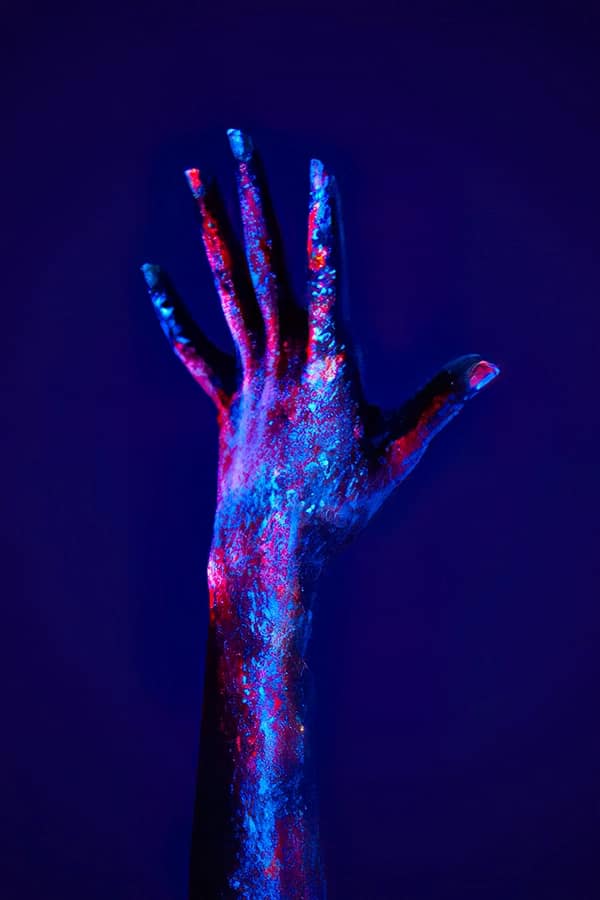 Imagen de refuerzo con mano iluminada con luz ultravioleta para destacar la suciedad biológica en la entrada de abril